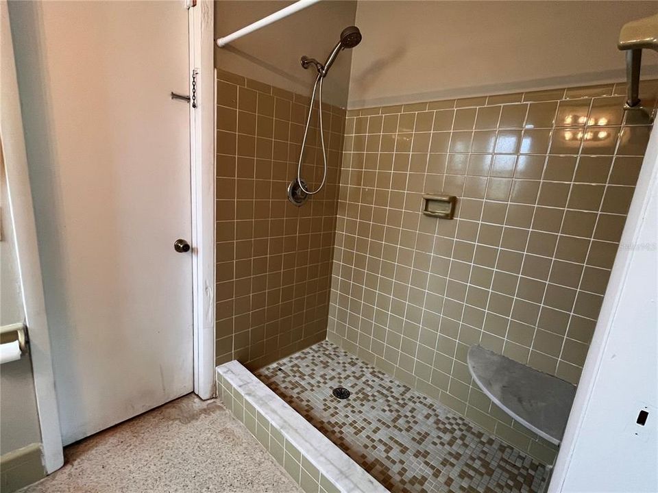 Primary bathroom with door to garage/laundry area