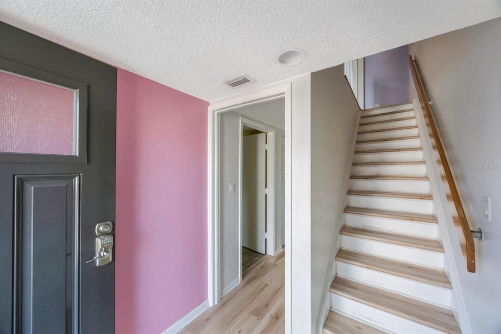 Entry leads to two bedrooms downstairs with larger storage closet, public areas upstairs.