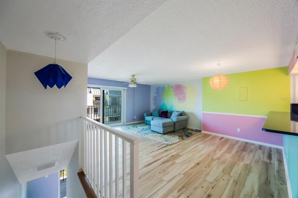 Light, bright great room, open floor plan with Venetian glass light brightening stairwell.