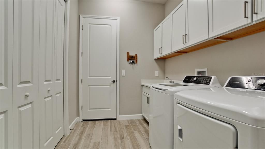 Laundry Room with Closet, Cabinetry and Utility Sink