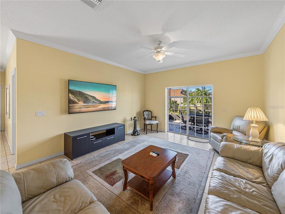 Living room with sliding doors to small screened in lanai out back overlooking pond