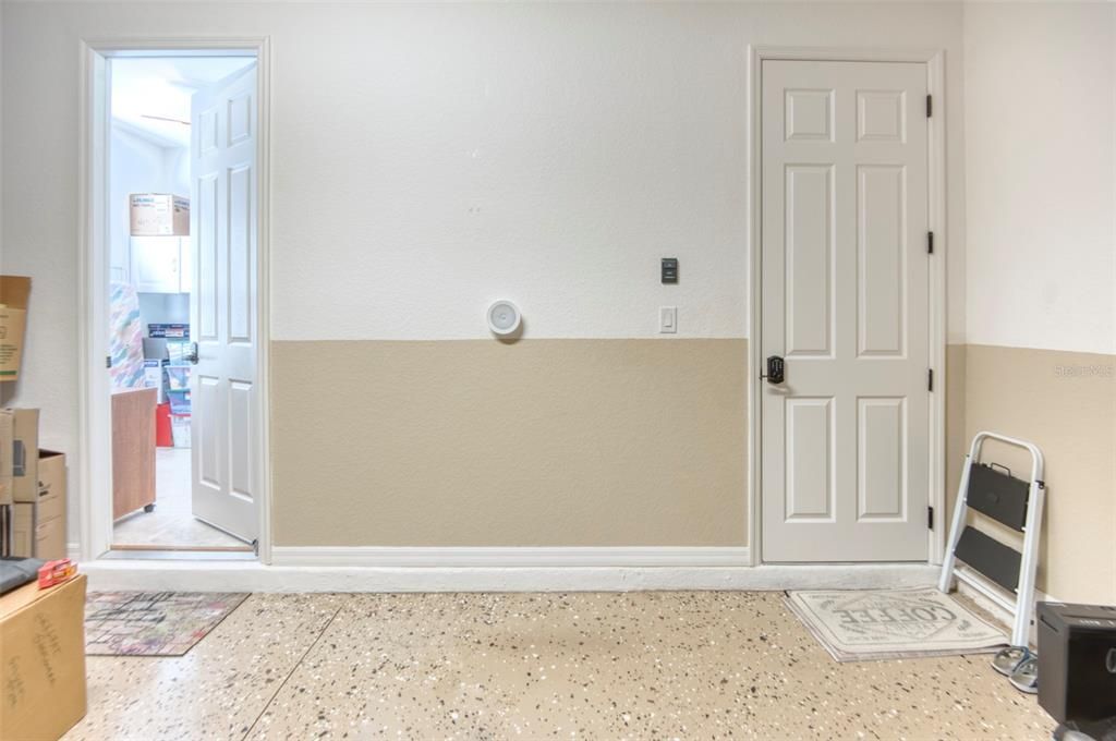 This view of the garage provides a glimpse of the epoxy floor coating with contrasting confetti, and a separate workshop/craft room/ sewing room - fully AIR-CONDITIONED!