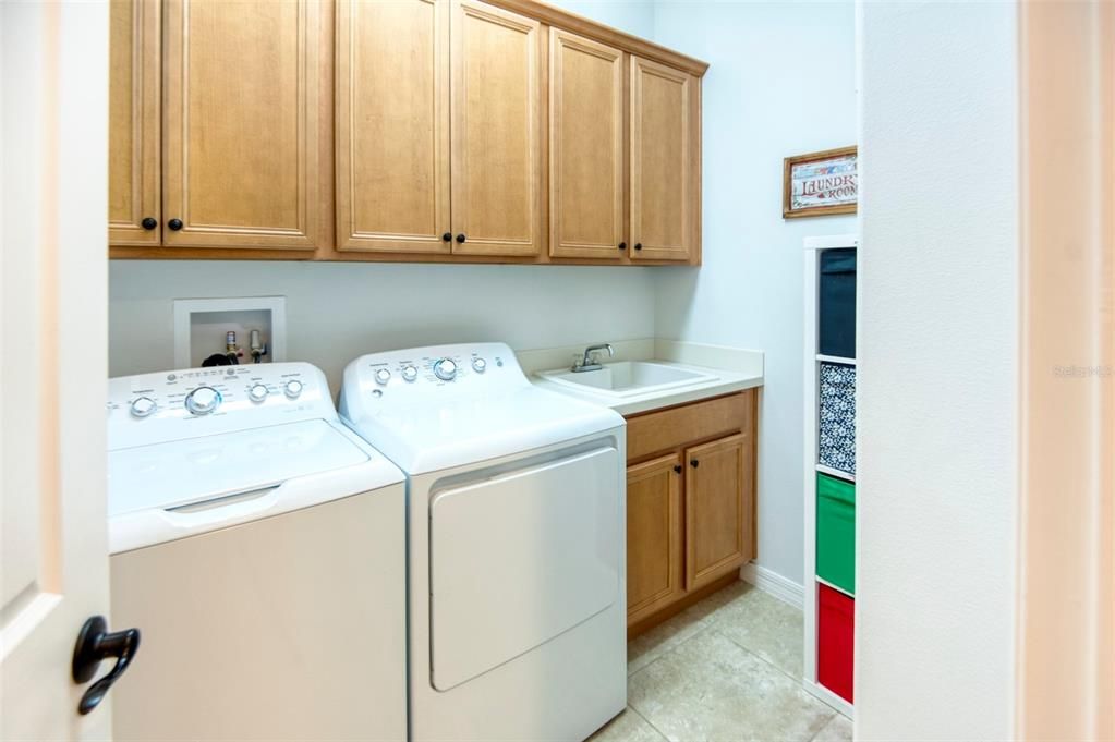 This home has a fully tricked-out laundry room with cabinets and a handy utility sink. Washer and dryer stay!