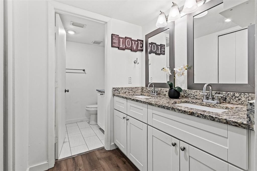 The master bathroom features a spacious walk-in closet designed by Closets by Design, providing ample organized shelves for your clothes and belongings and double vanity with a granite countertop, 2 sinks and 2 large mirrors.