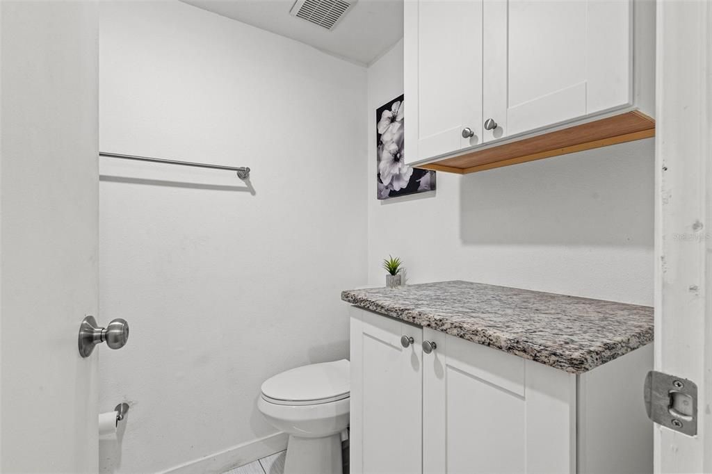 The private WC area includes a walk-in shower (on the left) and additional cabinet space with granite countertops, ensuring relaxation and functional experience.