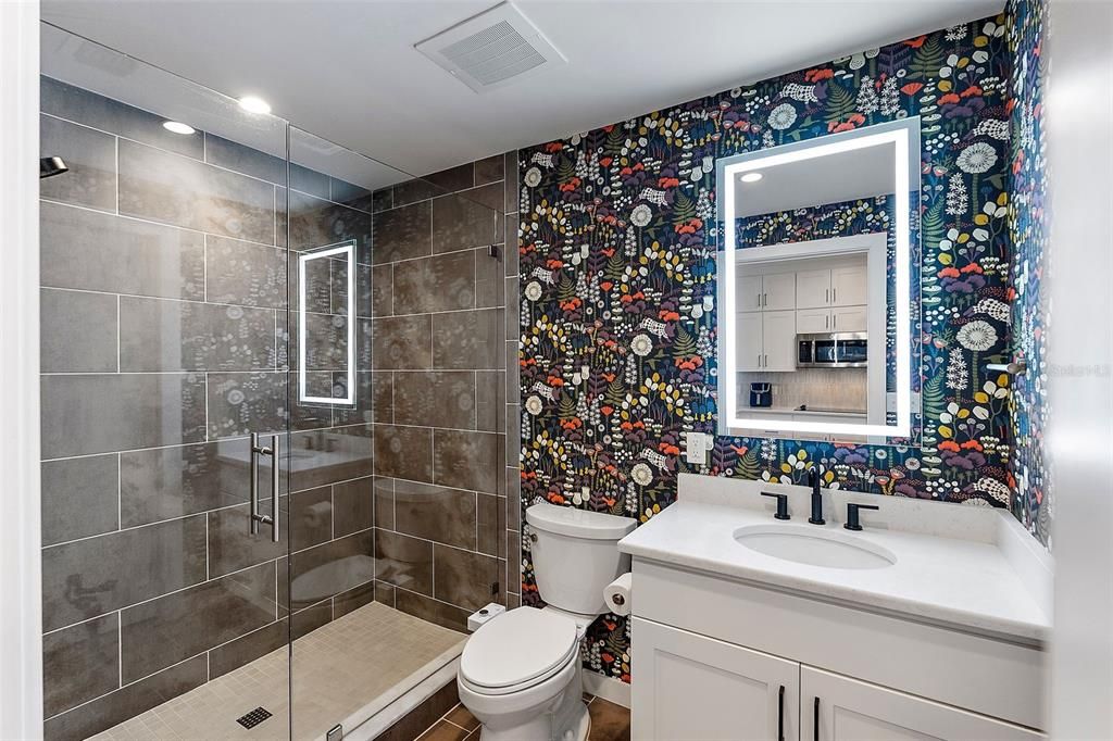 The guest bathroom features a vibrant and playful wallpaper