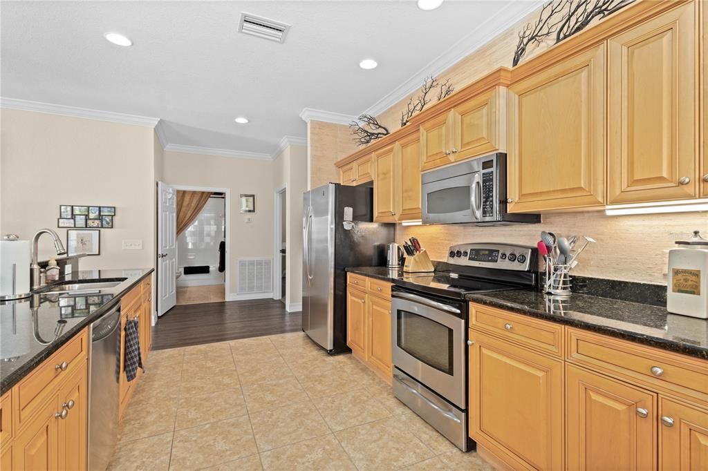 Kitchen with stainless steel appliances and recess and under cabinet lighting.