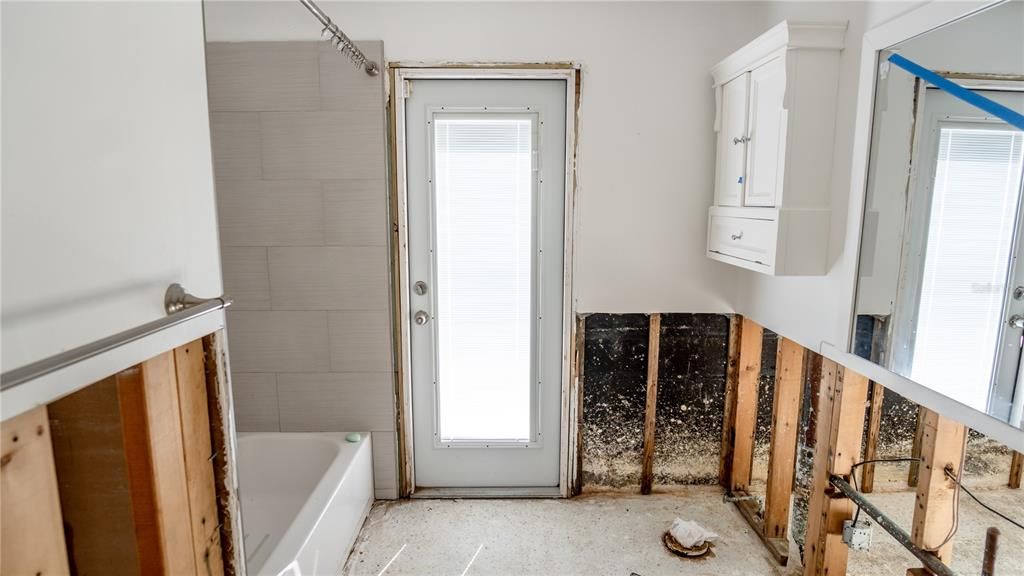 Hall Bathroom w/ Door Leading Out To Pool