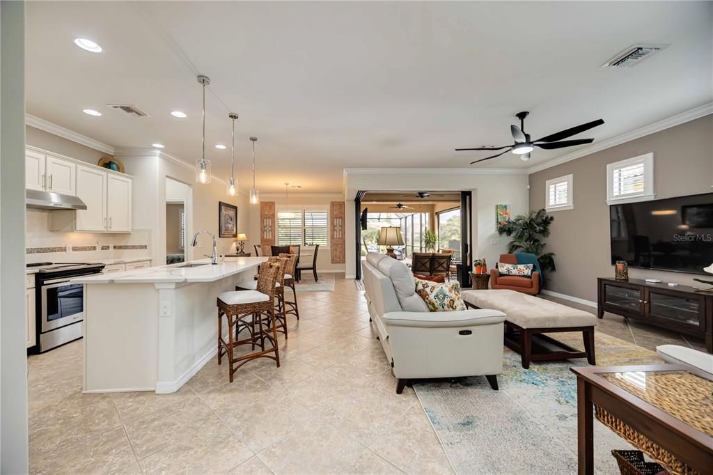 Open living space with zero corner door to expansive outdoor lanai and pool.