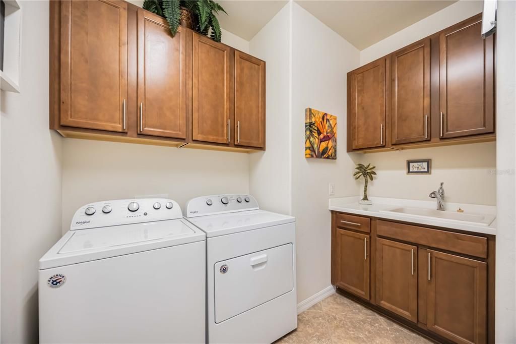 Full size laundry with sink and cabinetry