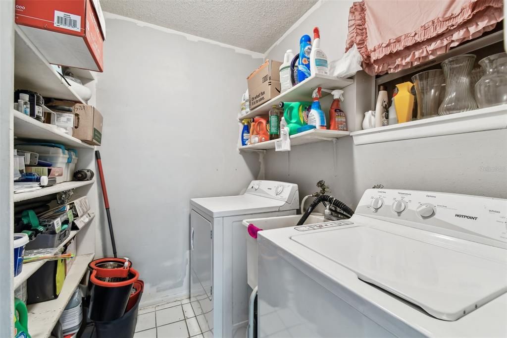 Laundry room with ample shelving.