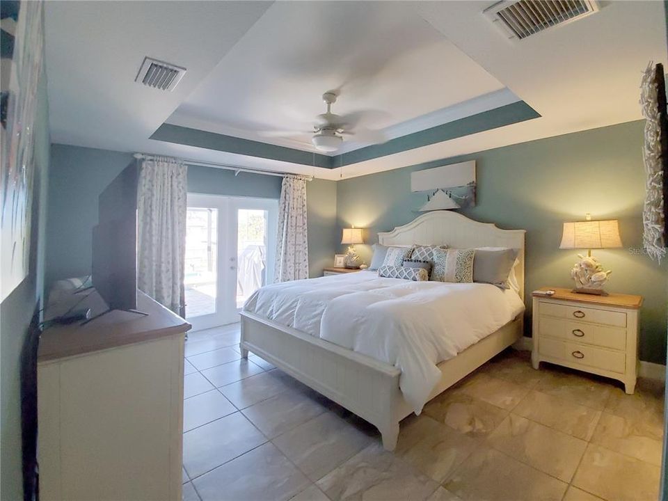 Master Bedroom has Tray Ceiling and Crown Moulding with French Doors out to Lanai and Pool