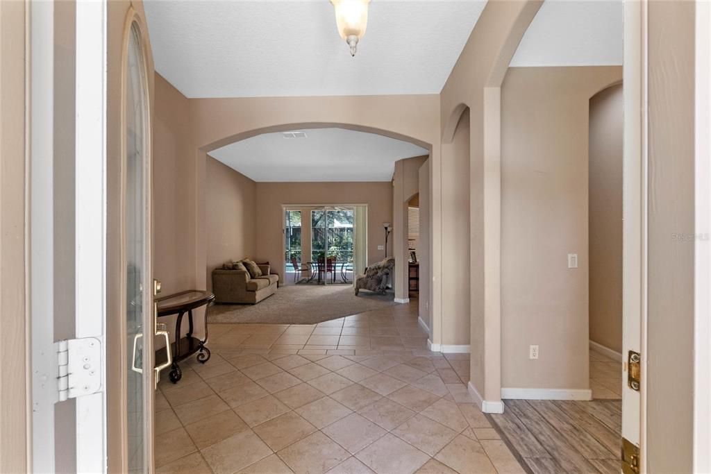 Foyer view from the front door. Office and primary bedroom to the right. Formal Dining to the right and formal living room is straight ahead.