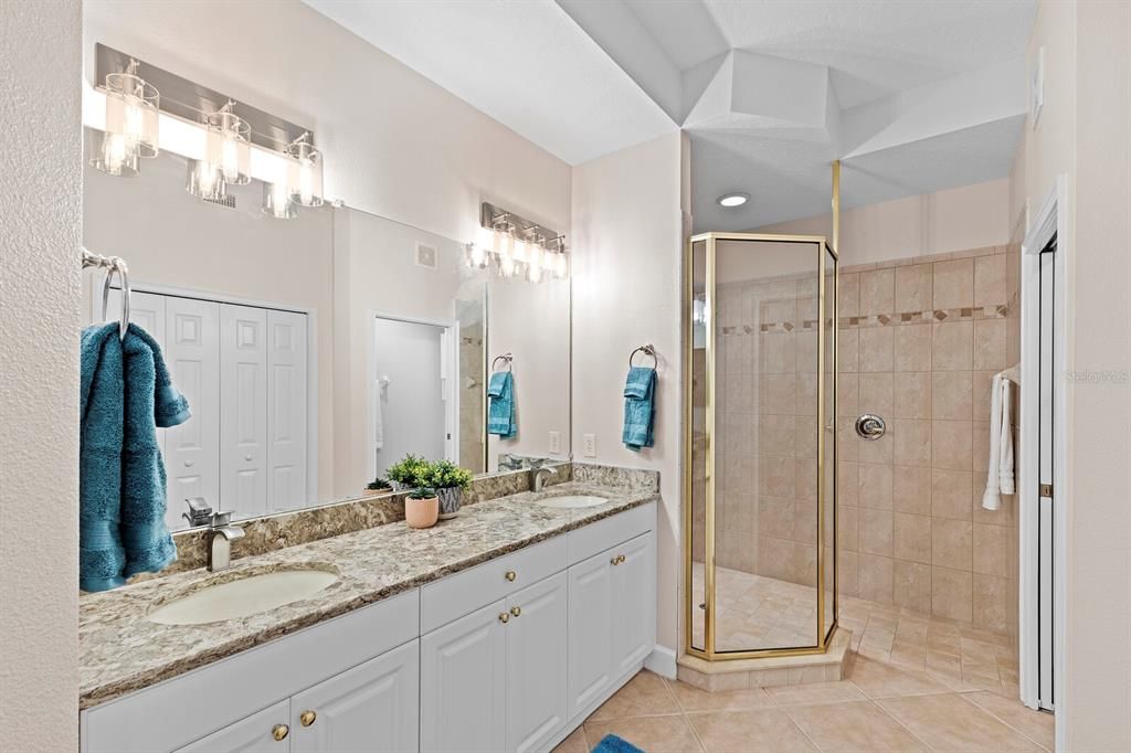 Large primary bathroom with dual singk vanity and updated light fixtures