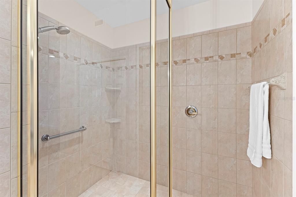 Spacious tiled, walk-in shower with hand rails