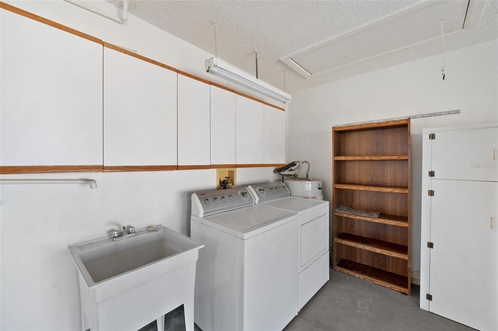 Laundry area, utility sink and some of the cabinets/storage in the garage