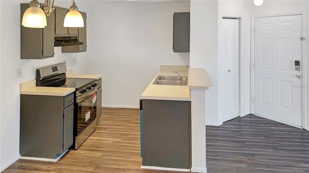 Kitchen as seen from entrance to Master Bedroom! !  Be the First One to Ever Use Your NEW STOVE, NEW DISHWASHER, and NEW REFRIGERATOR too! Brand NEW WOOD FLOORING and FRESH PAINT