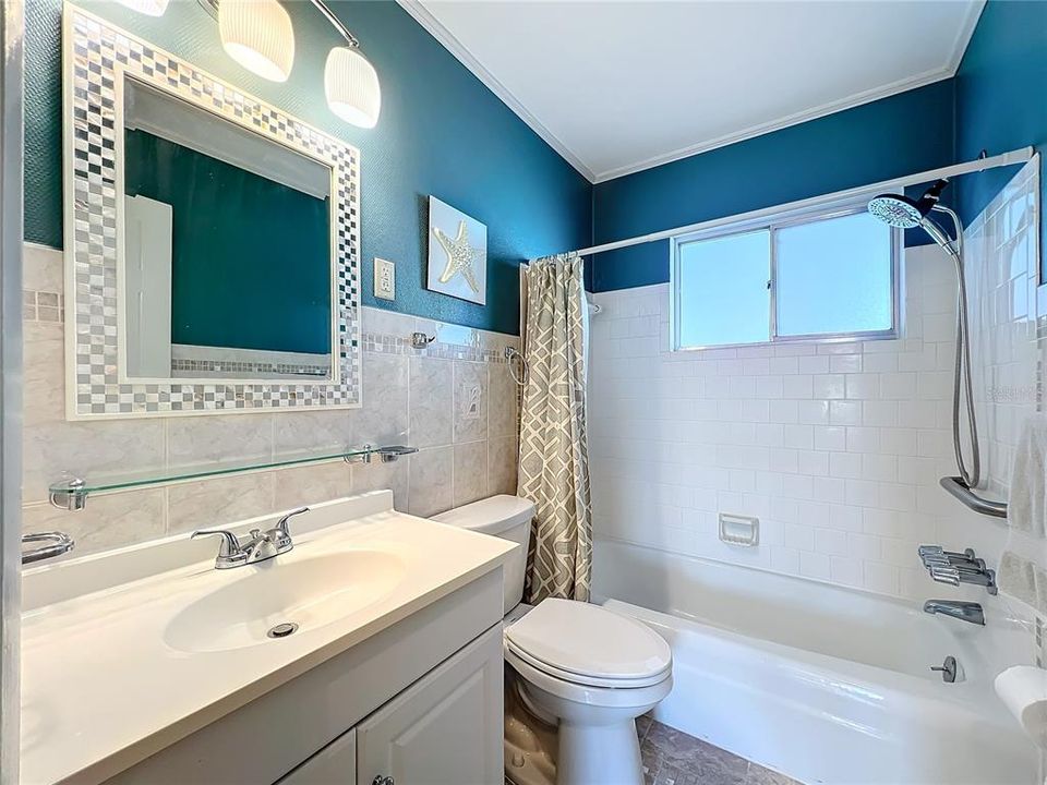 Nicely updated bathroom with newer wall, floor tile, faucets and shower head.