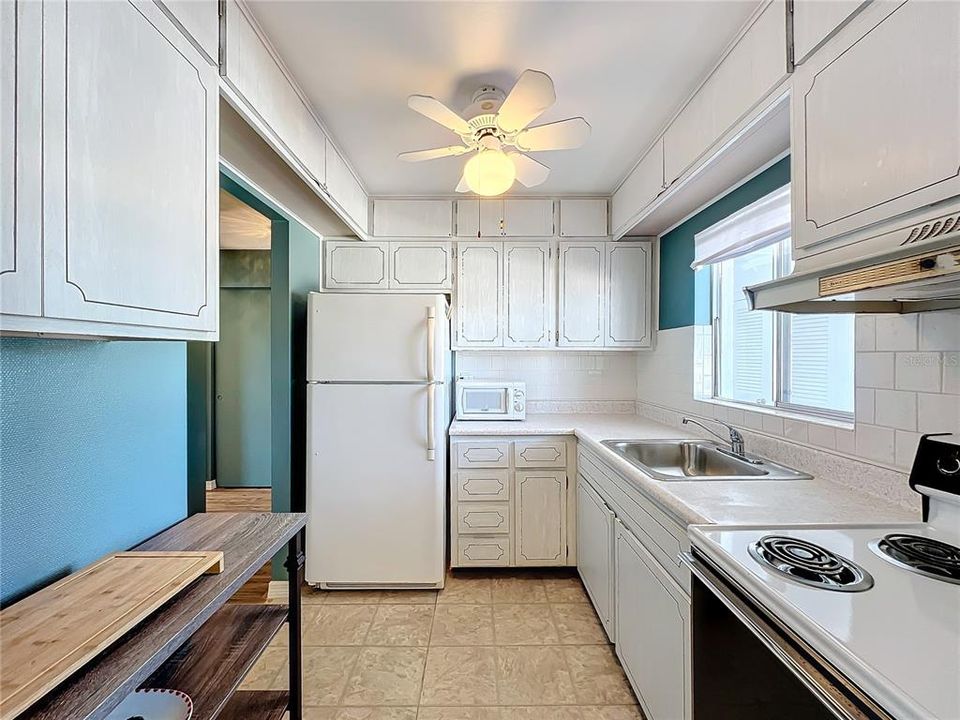 Kitchen with ceiling fan for comfort.