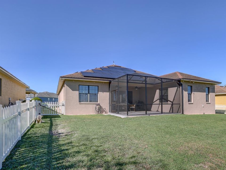 Back of the home. Screened lanai and Solar panels.