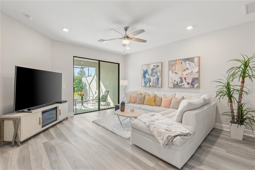 Living room includes a sliding glass door to the extended screened-in lanai