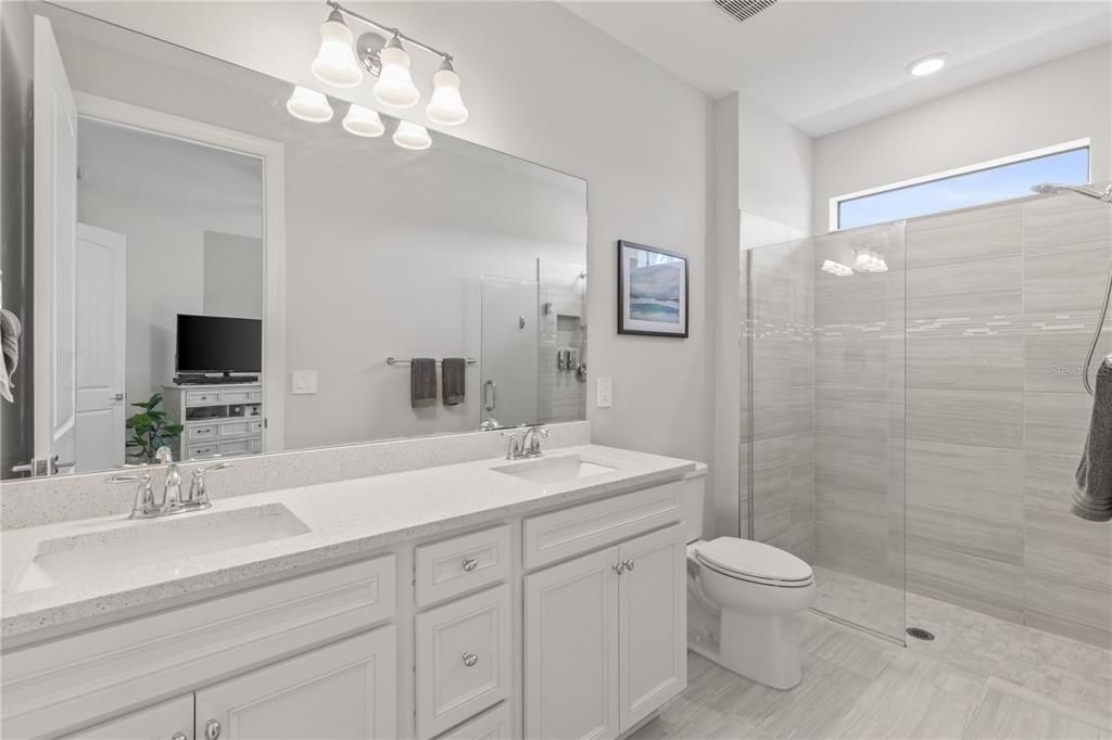 Owners ensuite bathroom features dual sinks, and frameless glass enclosed walk-in shower.