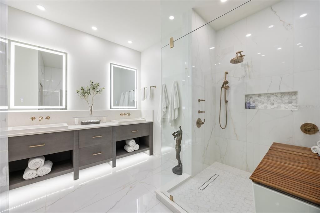 Large primary bathroom with dual custom underlit vanities and backlit mirrors