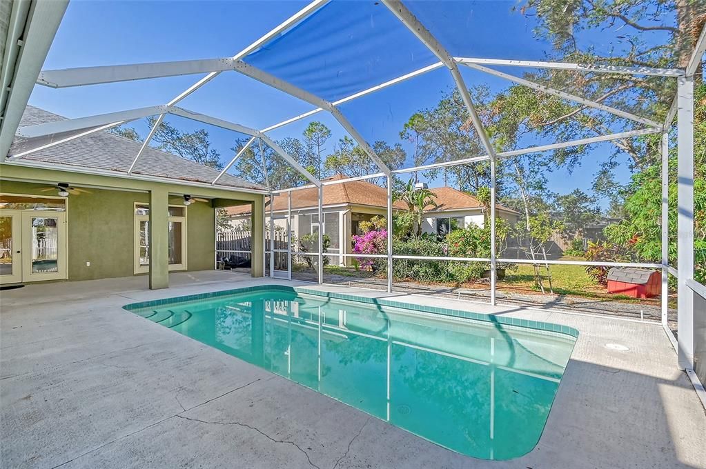 The outdoor living area with covered lanai and pool