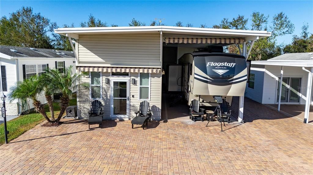 Custom layout includes driveway pavers, retractable awnings over front entry and RV port.