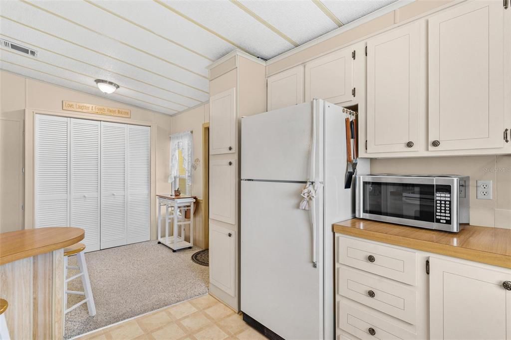 View from living room area of kitchen Closet pantry, eat-in area, and entry way