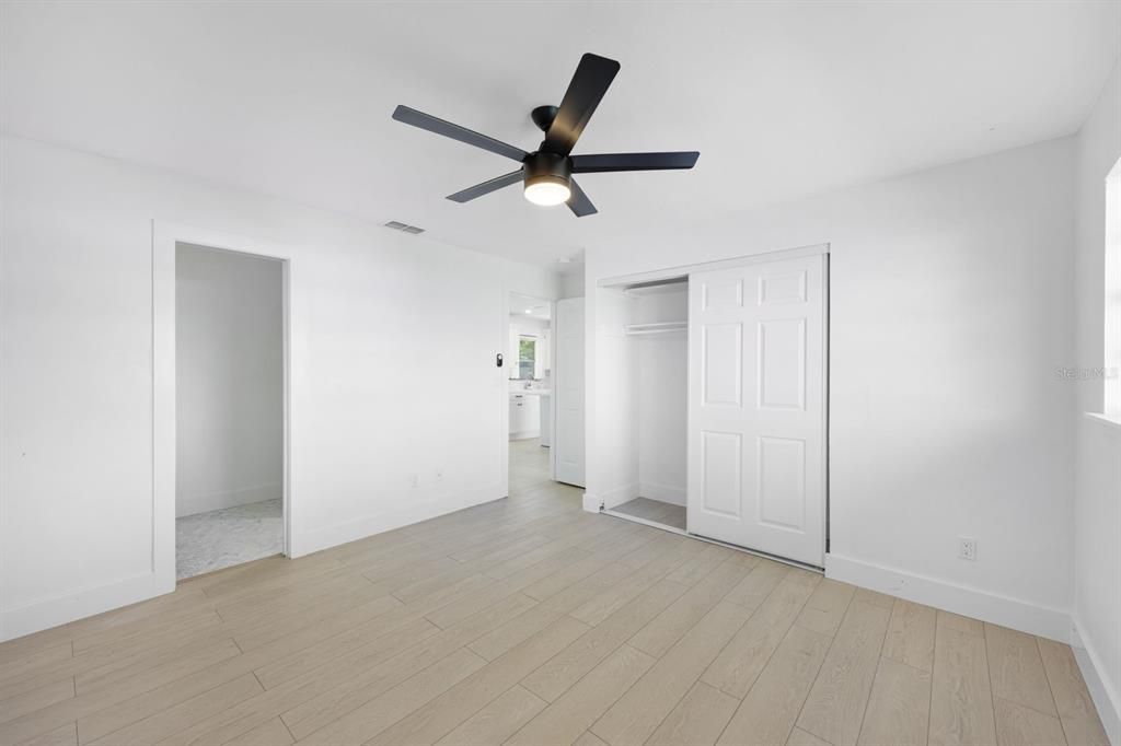 Unfurnished bedroom featuring ceiling fan, light hardwood / wood-style floors, and a closet