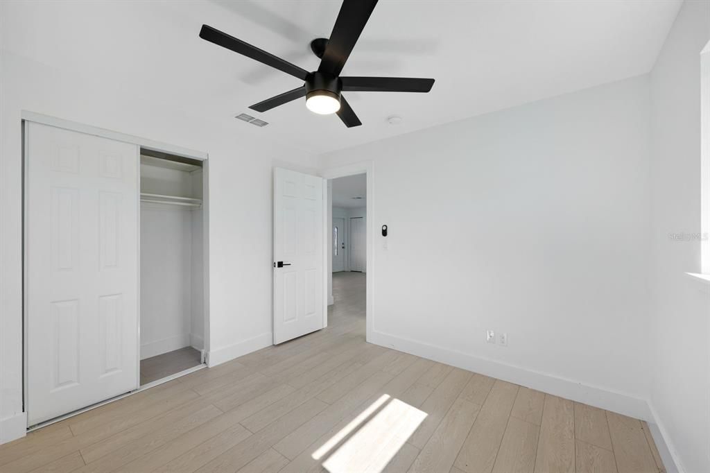 Unfurnished bedroom with ceiling fan, light hardwood / wood-style floors, and a closet