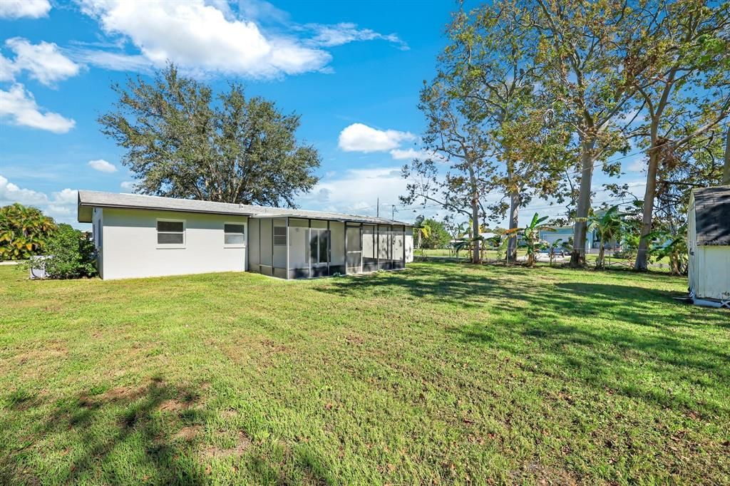 Back of property featuring a sunroom and a yard