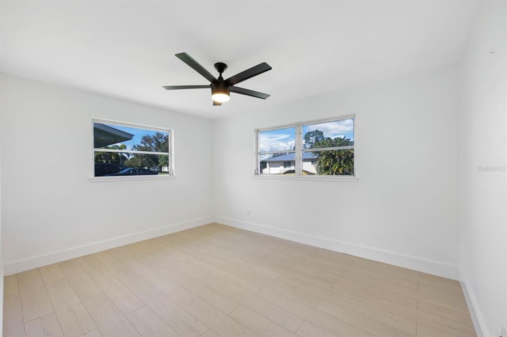 Unfurnished room featuring ceiling fan, plenty of natural light, and light hardwood / wood-style flooring