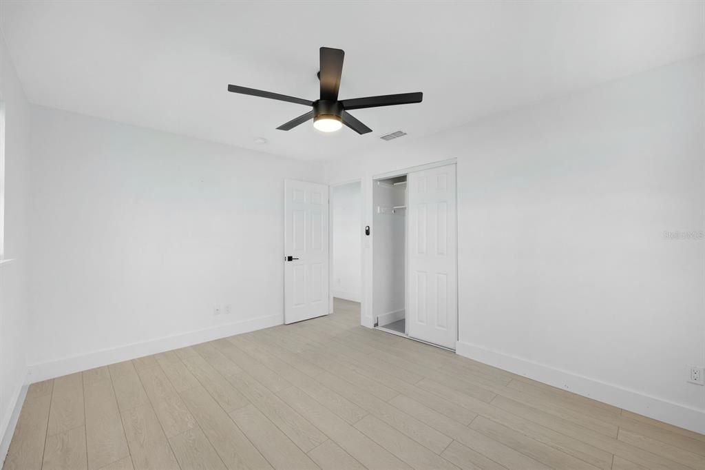 Unfurnished bedroom with a closet, light hardwood / wood-style floors, and ceiling fan