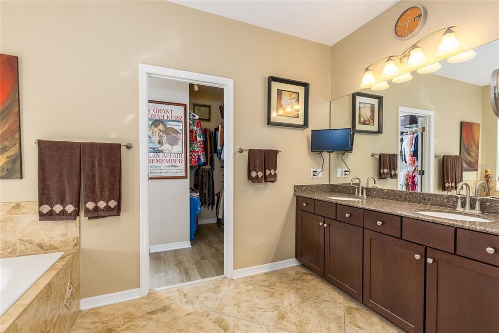 Primary bath with his/her sinks and a soaking tub with remote privacy shade.