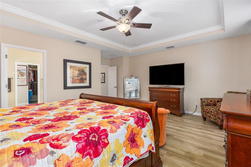 Primary bedroom has tray ceiling with crown molding.