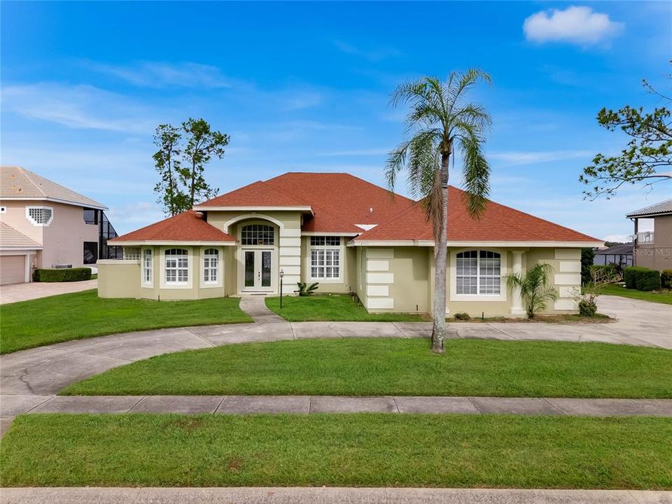 Front exterior of home with wrap-around driveway.