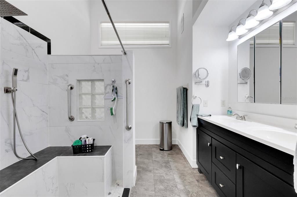 Master Bathroom offers dual sinks, walk-in, oversized shower with bench, grab bars, and 3 shower heads.