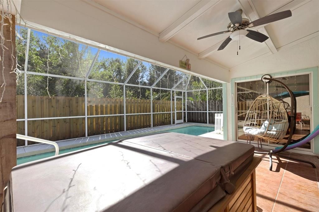 Screened lanai is partially covered. Preserve is behind the fence.