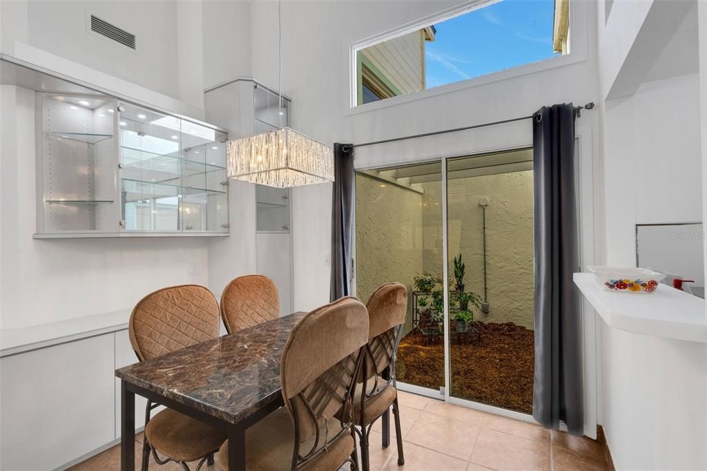 Dining room with built-in buffet and China cabinet. Sliders lead out to an atrium, bringing the outdoors in.