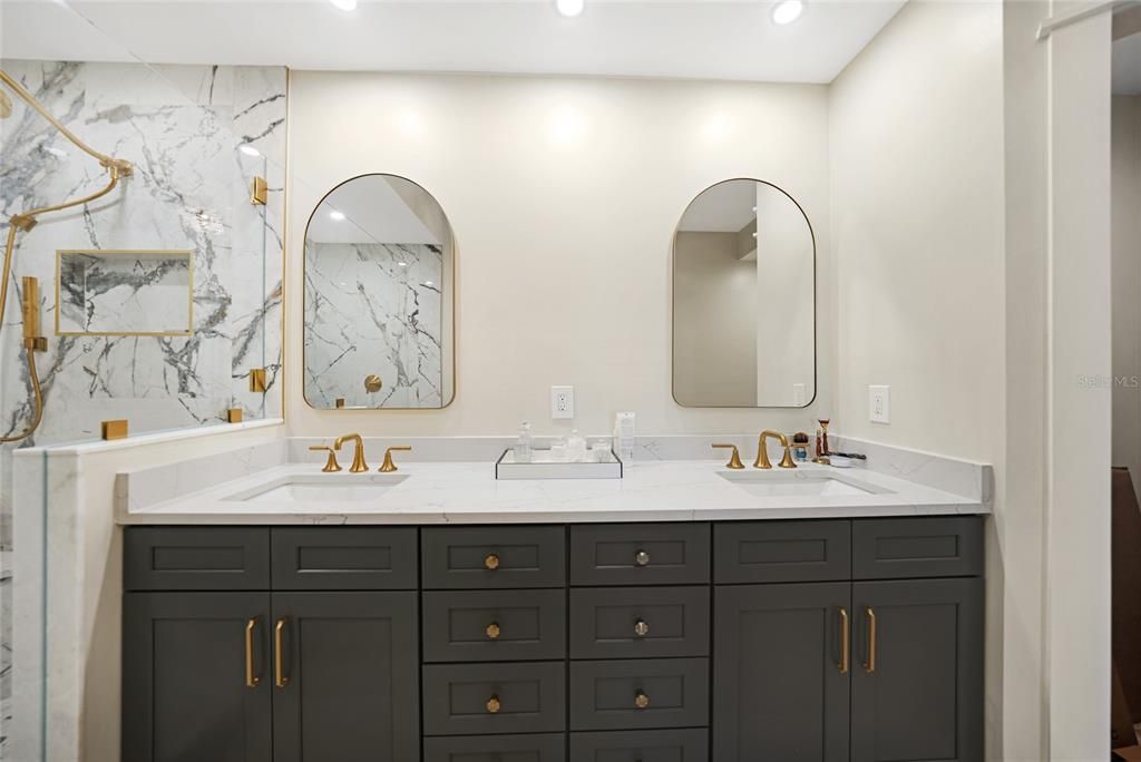 Double vanities next to huge walk-in shower.