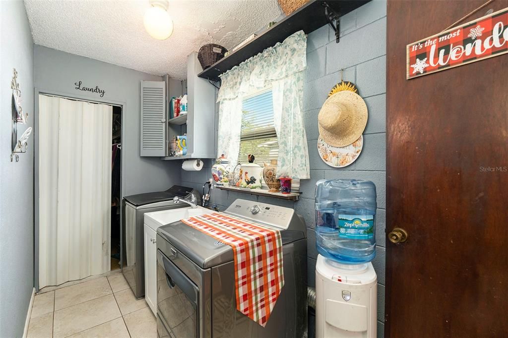 Laundry room with storage closet and utility sink