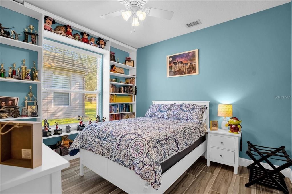 3rd bedroom with built-in shelving and tile flooring