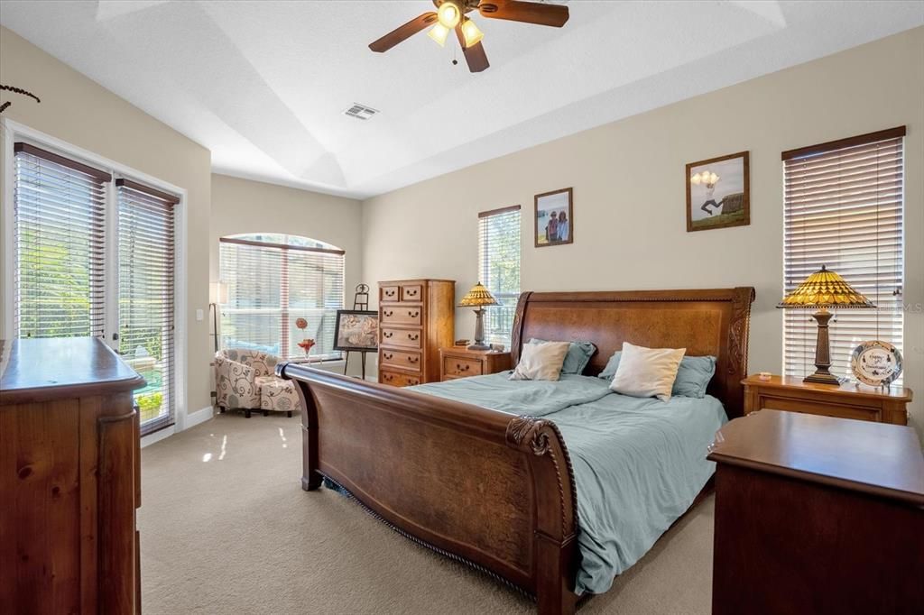 Primary bedroom with reading nook, tray ceilings and French doors to your lanai and pool