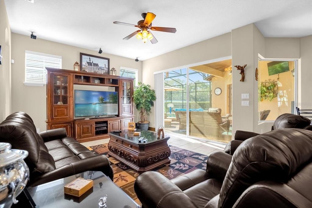 Family room with sliders to the pool, surround sound system, neutral paint and plenty of natural light