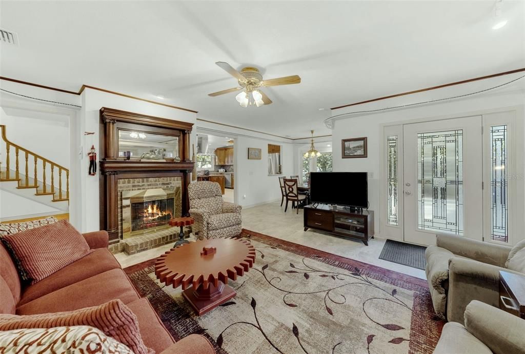 Family room with wood-burning fireplace and a view of dining room area and kitchen