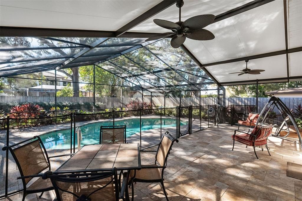 Large covered lanai area, travertine deck and screened pool enclosure