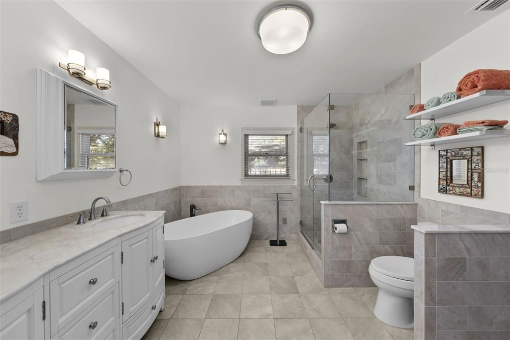 Primary bathroom with large vanity, marble countertops and dual sinks