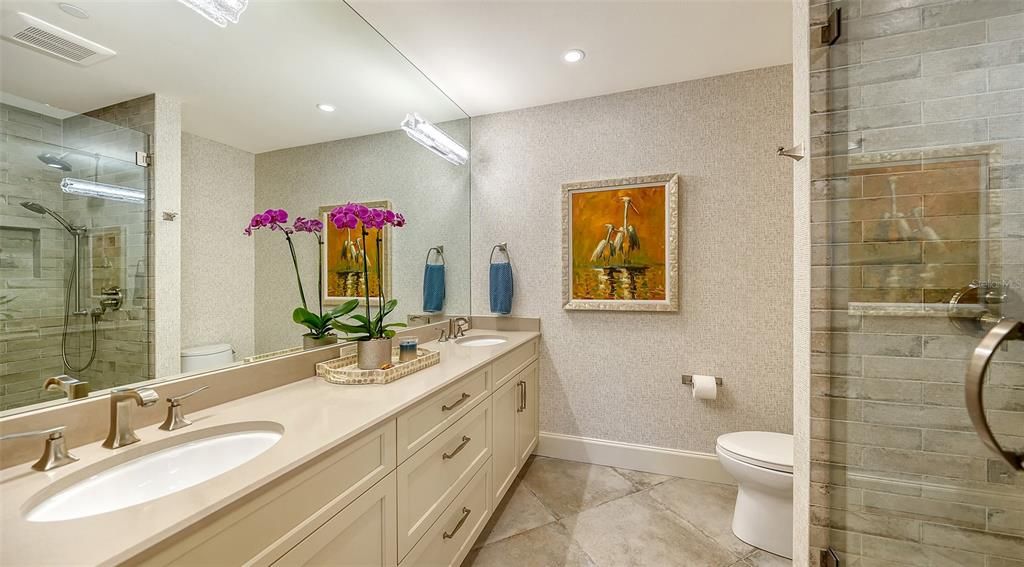 En suite bath with walk-in shower, double sinks, beautiful cabinetry.